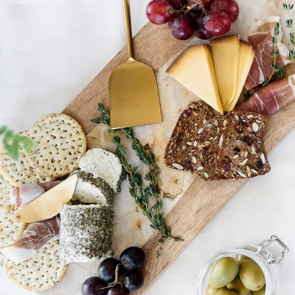 seasonal gathering with charcuterie - crackers, cheeses, fruits, herbs and nuts
